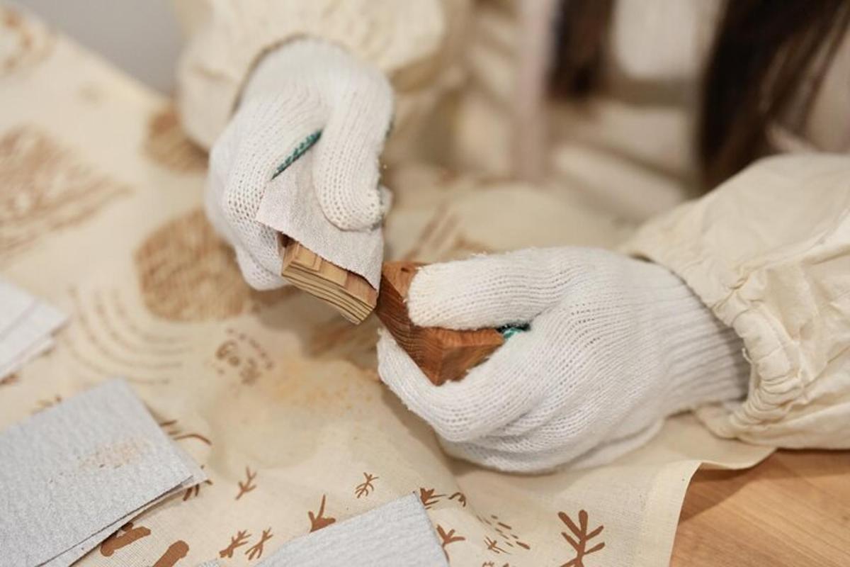 a stuffed animal with white gloves holding a piece of wood