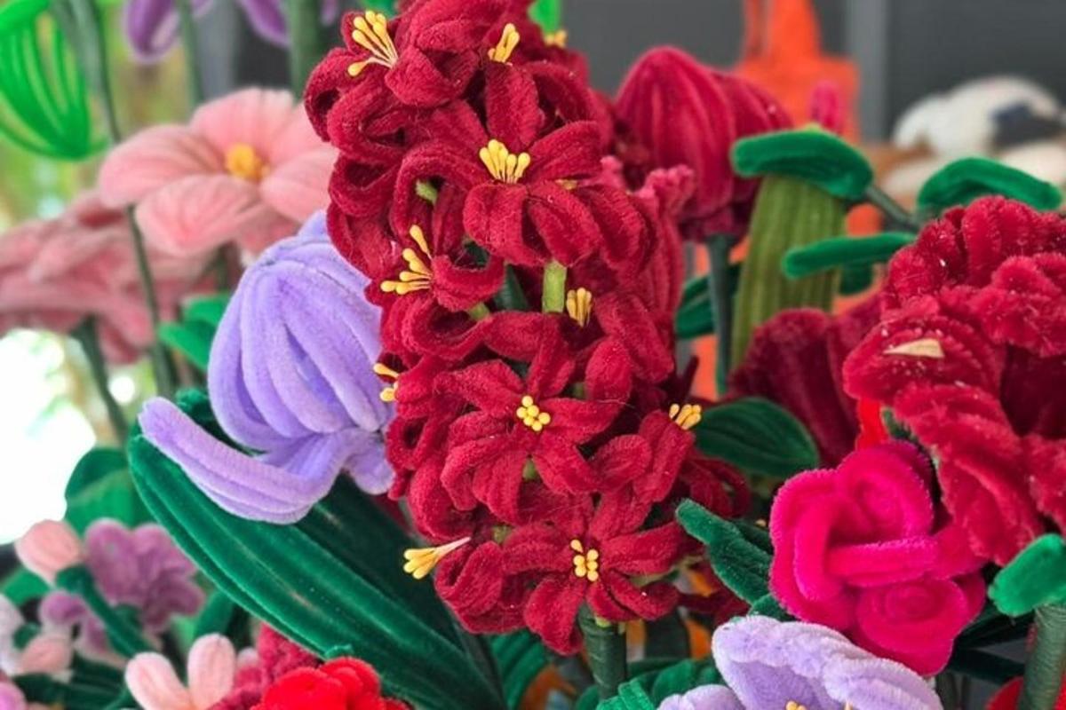 a group of red and purple flowers with green leaves