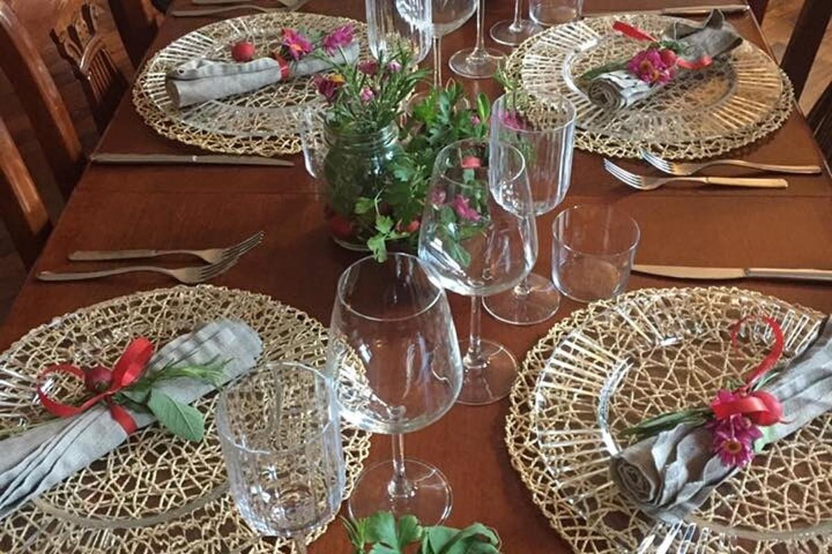 uma mesa de madeira com pratos e taças de vinho sobre ela