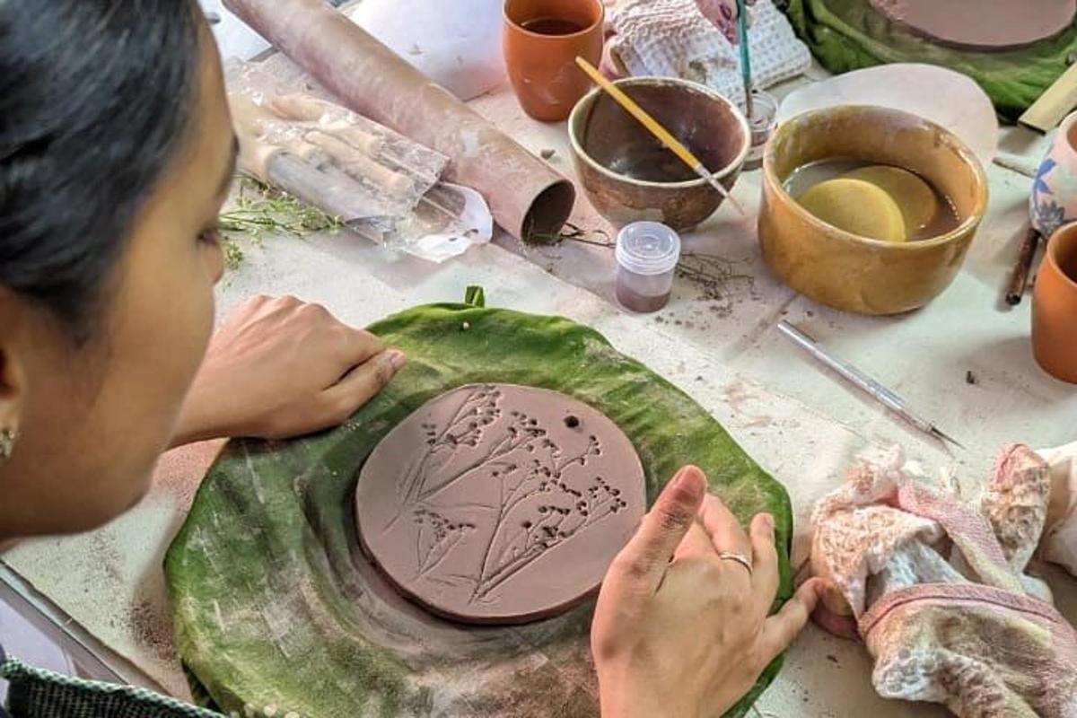 a woman is painting a tree on a green pepper