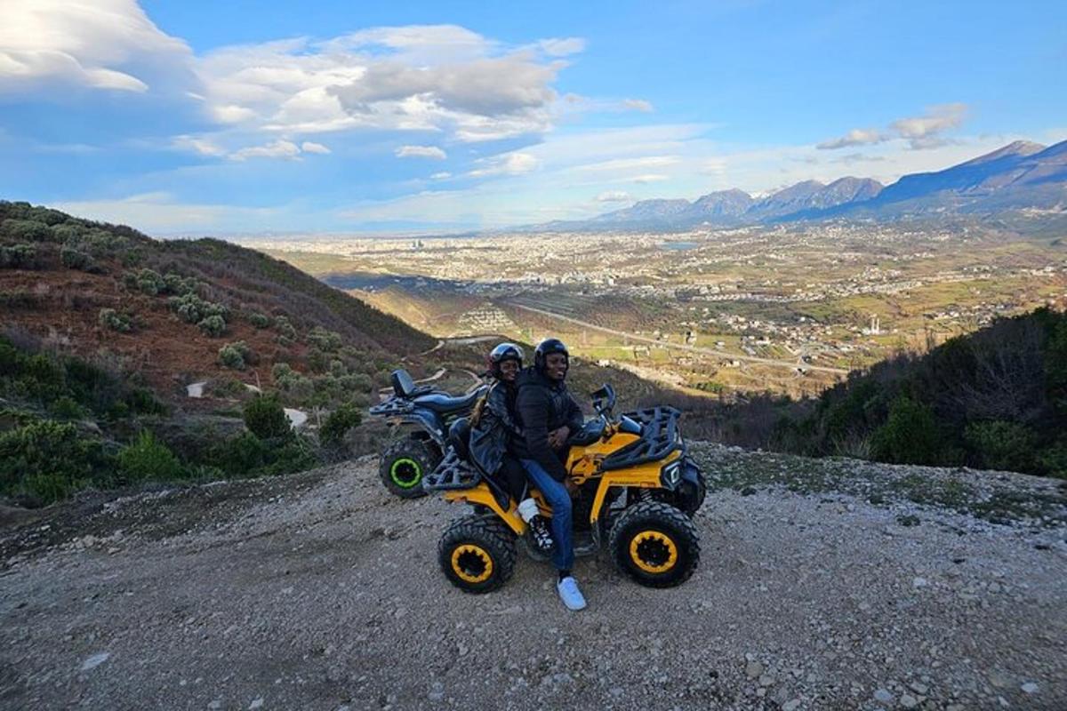 due persone sedute su quad in cima a una collina