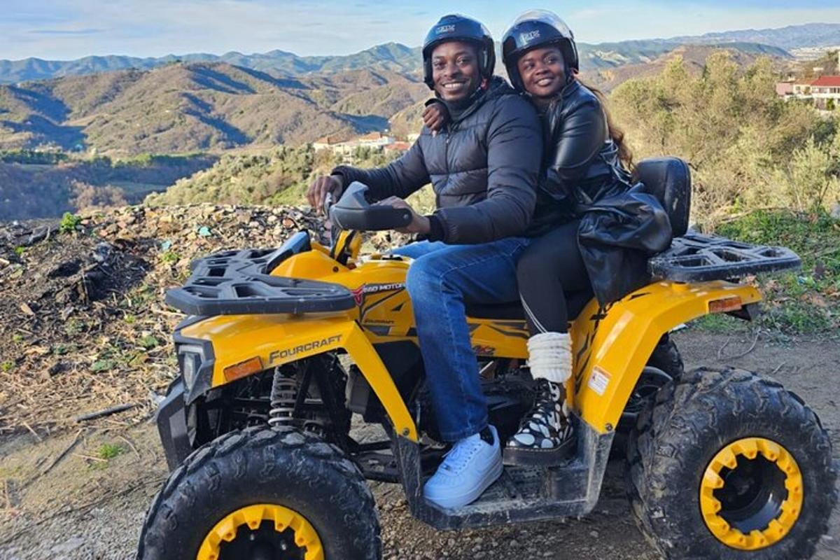 un uomo e una donna a bordo di un veicolo a quattro ruote su una montagna