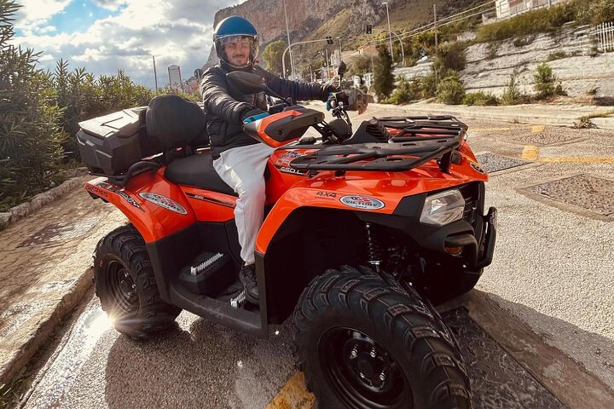 Egy férfi egy narancssárga ATV-n ül az úton