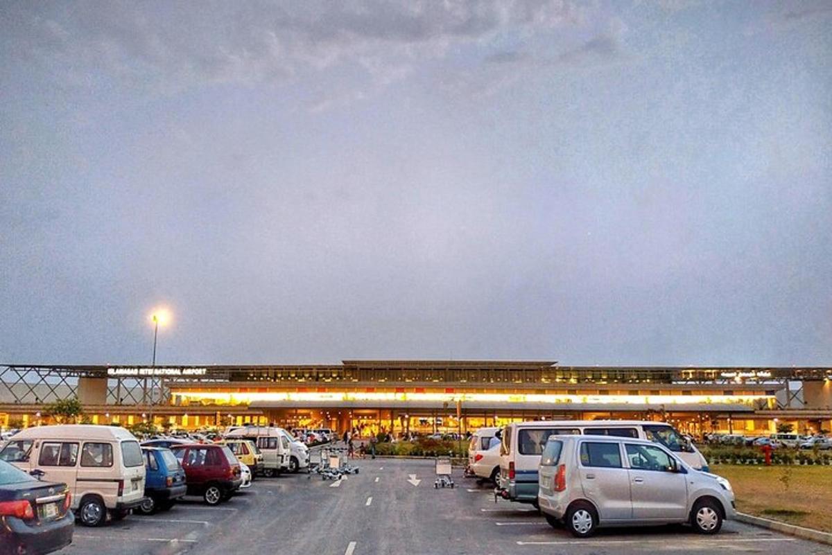 un parcheggio con auto parcheggiate di fronte a un aeroporto