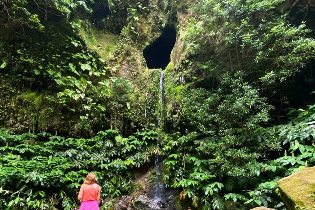 a woman standing in front of a tunnel in a forest