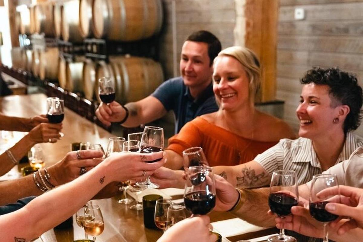 a group of people sitting around a bar drinking wine