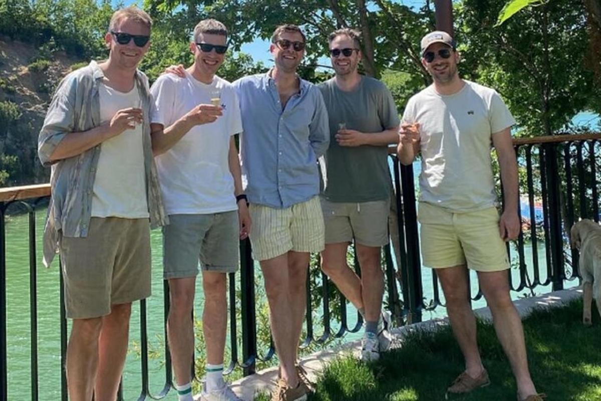 eine Gruppe von Männern steht vor einem Zaun
