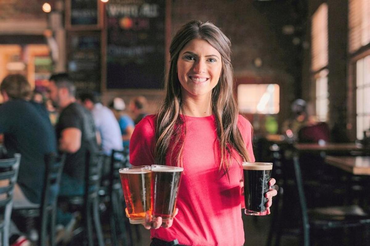 een vrouw houdt twee glazen bier vast