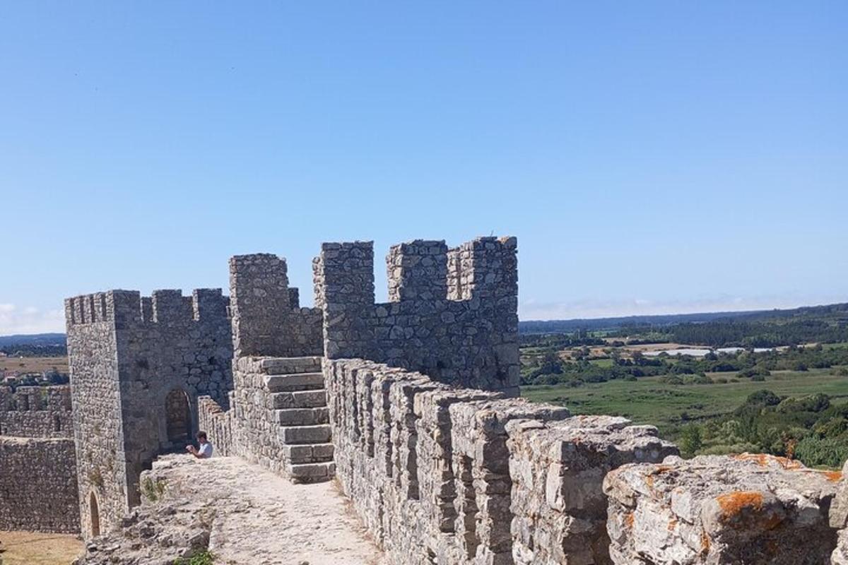 uma pessoa sentada no topo de um muro de pedra