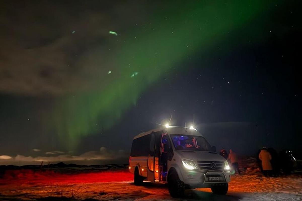 Un camión semirremolque estacionado bajo la aurora boreal