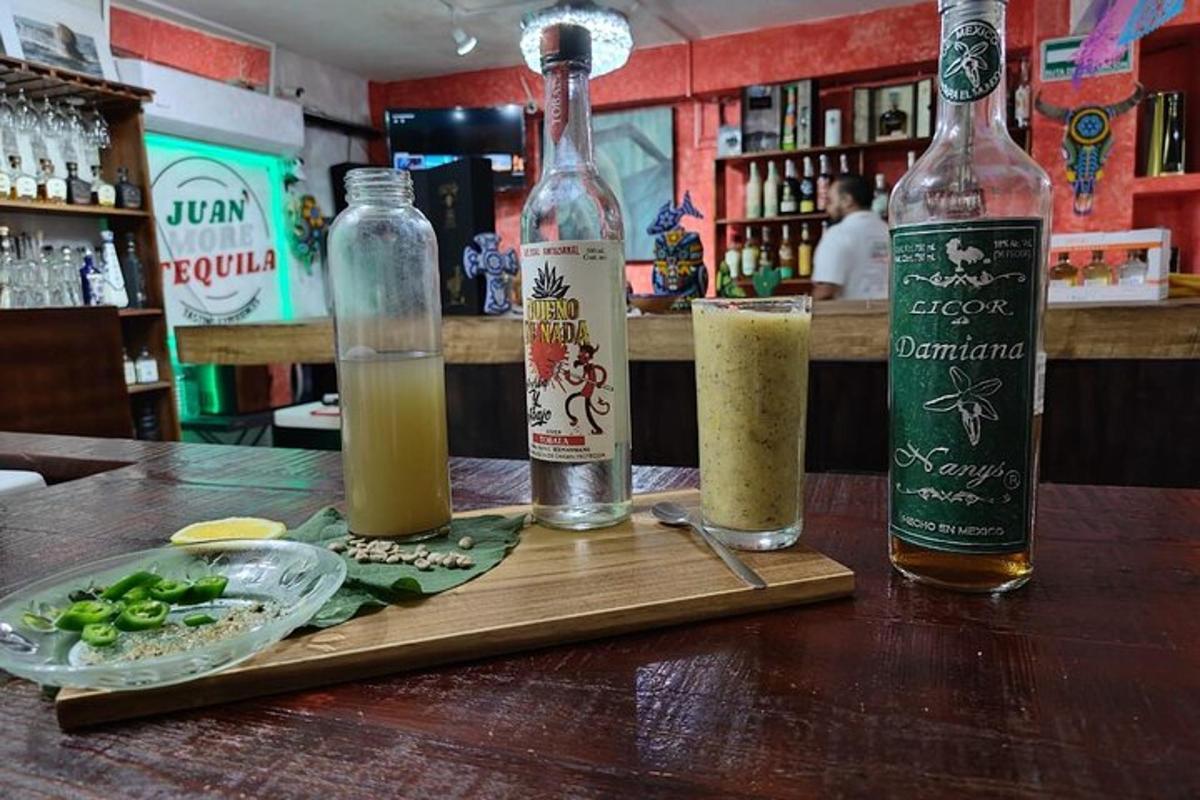 miza s tremi steklenicami alkohola in krožnikom hrane
