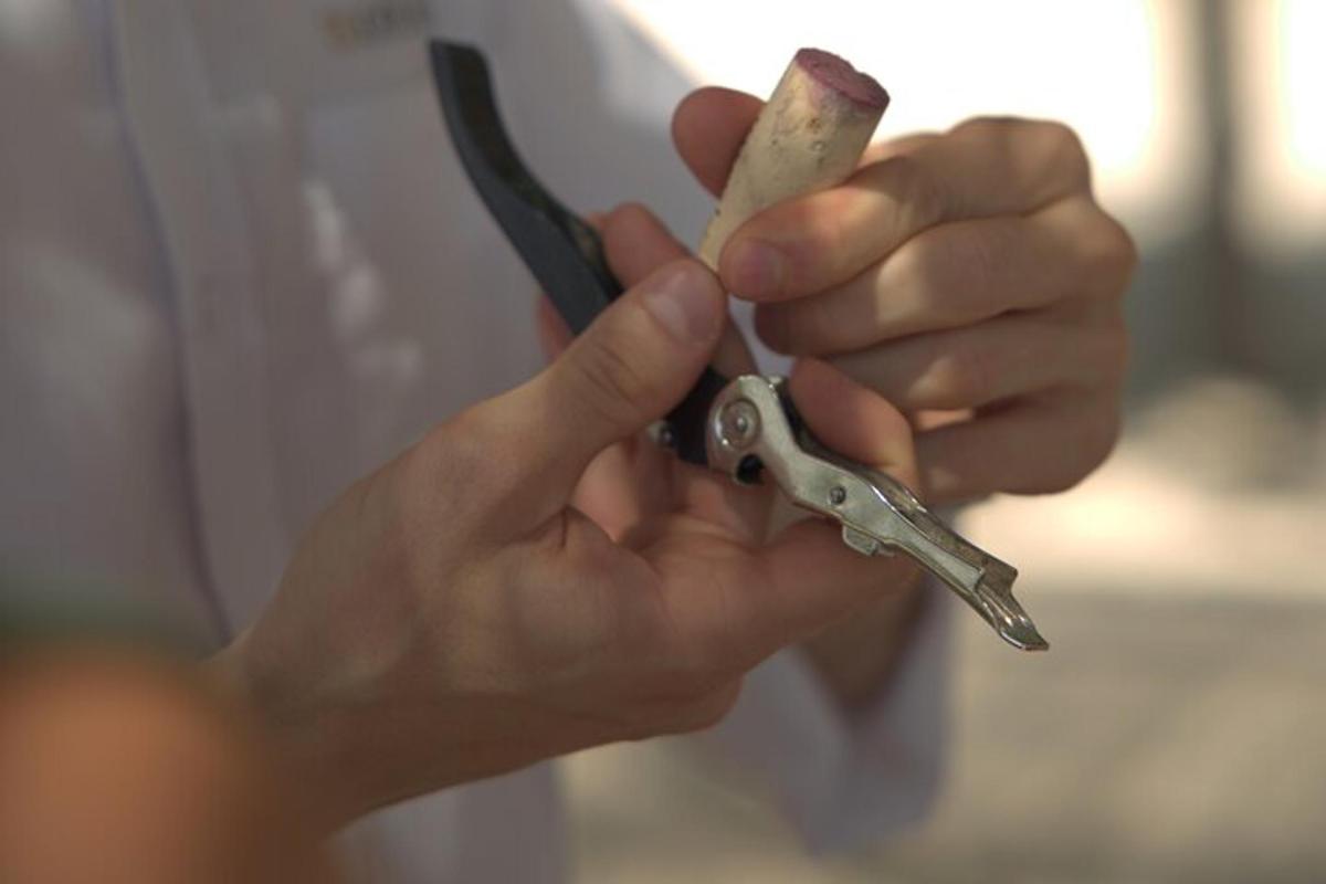 muž drží nůžky a kus ušpiněného materiálu