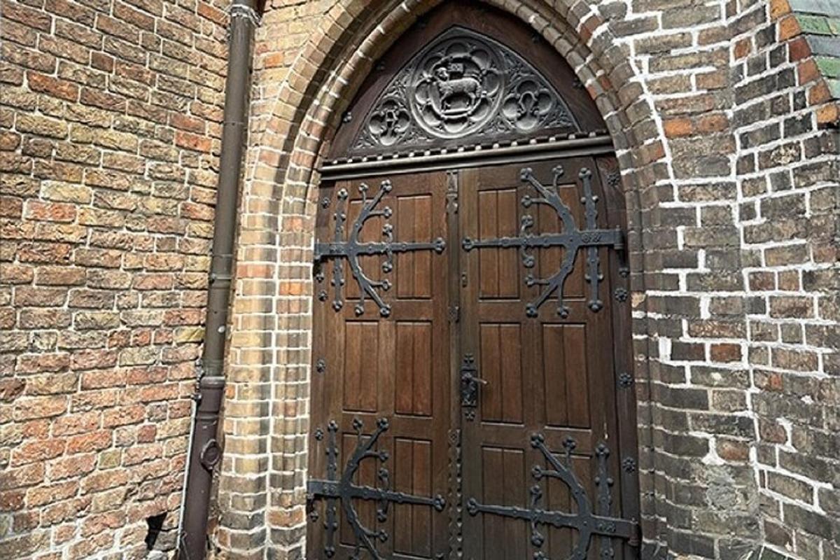 una grande porta di legno in un edificio di mattoni