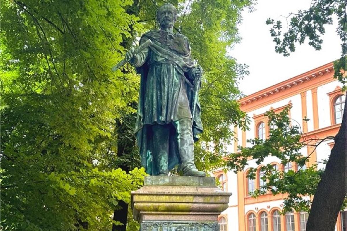 una statua di un uomo in piedi davanti a un edificio