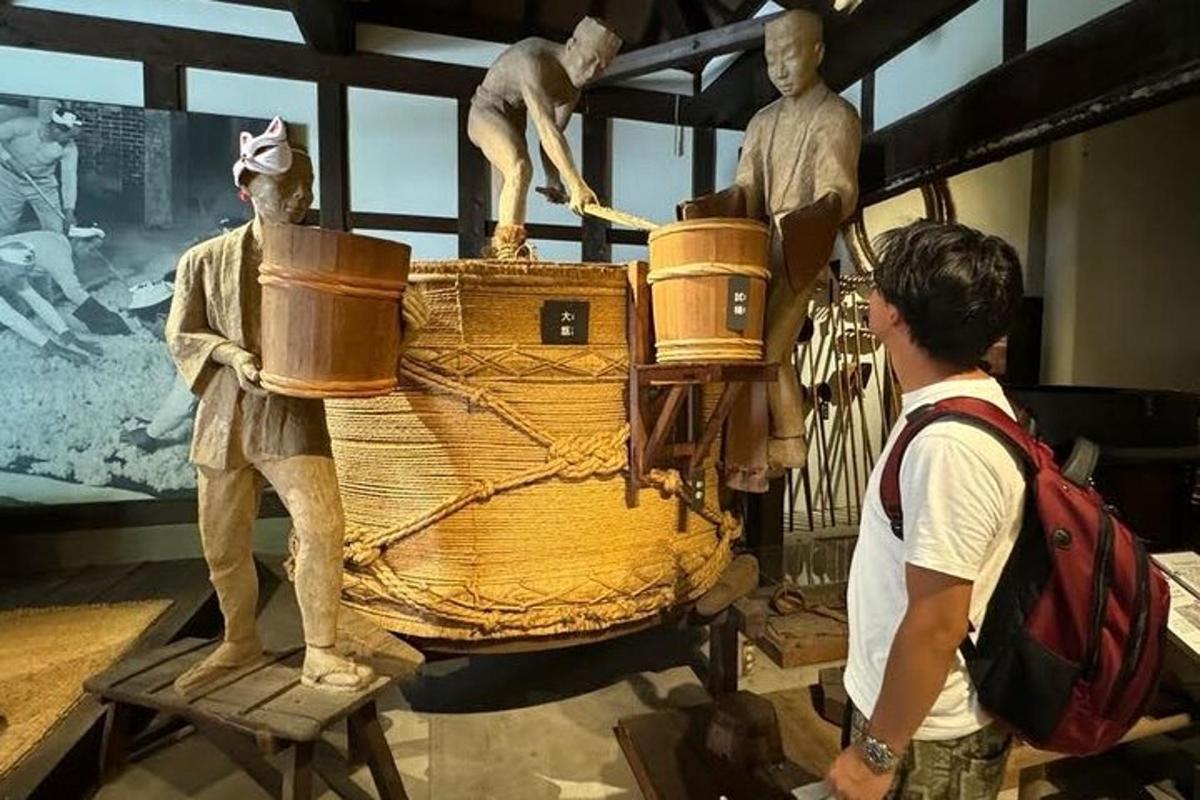 a man looking at a statue of a boat in a museum