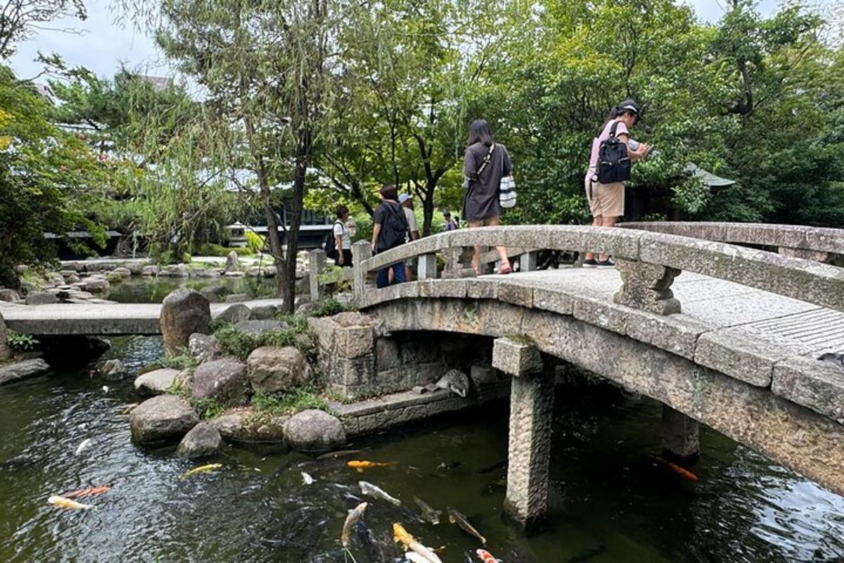 a group of people standing on a bridge over a pond