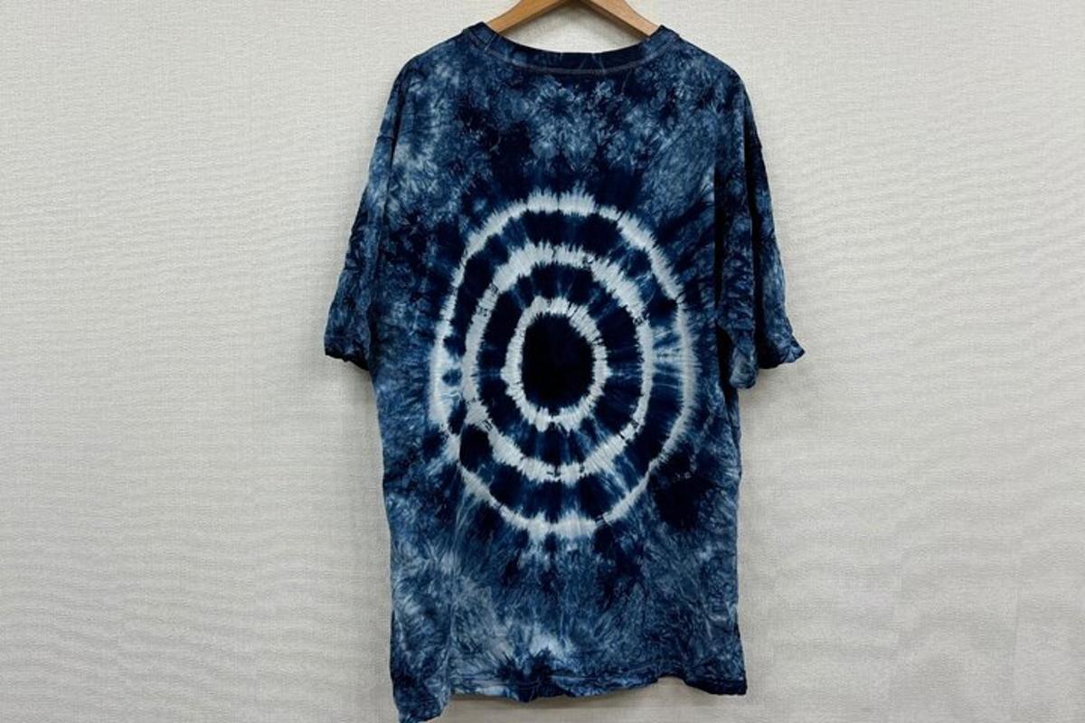 a blue tie dye dress hanging on a wall