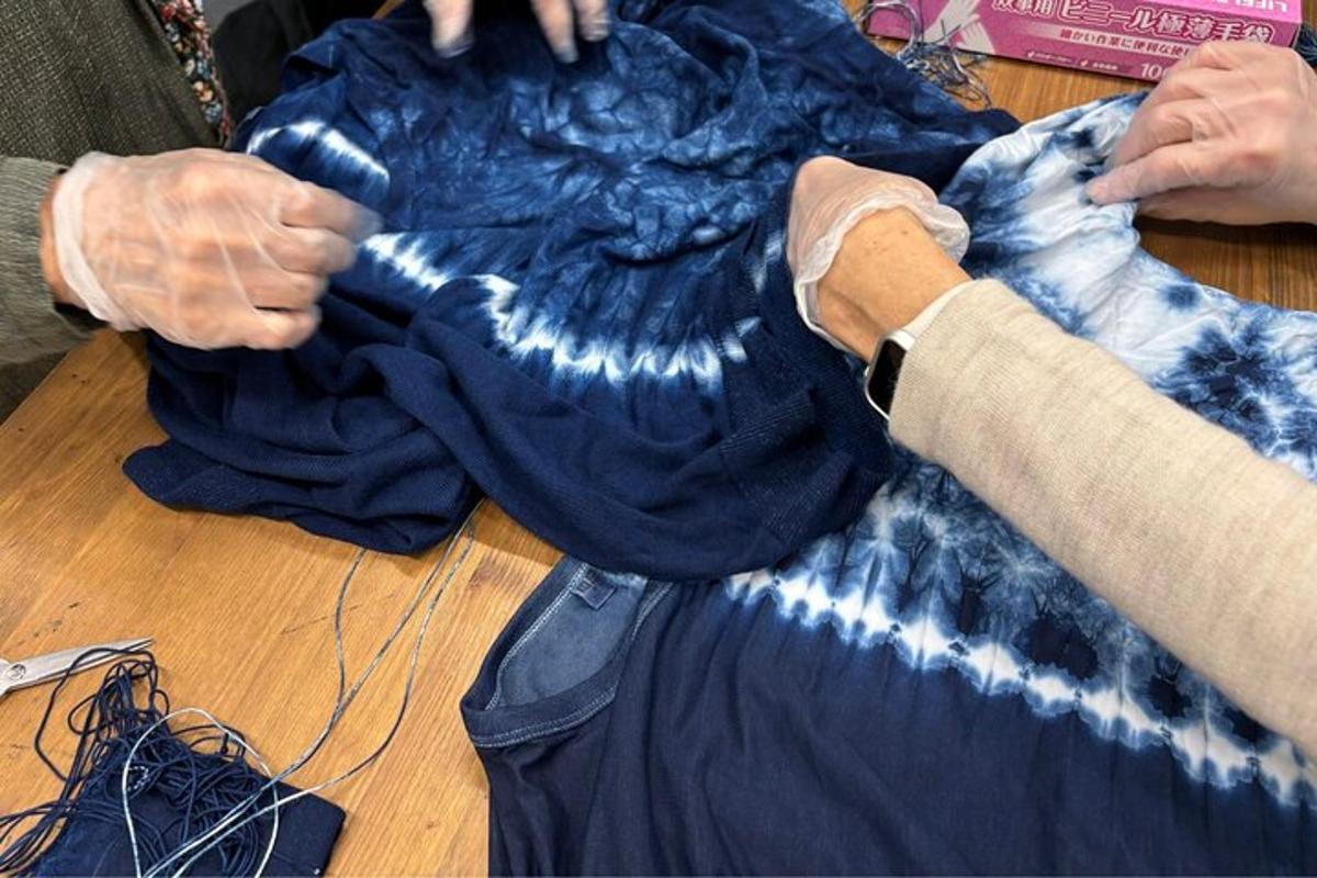 una persona treballant amb una camisa blava sobre una taula