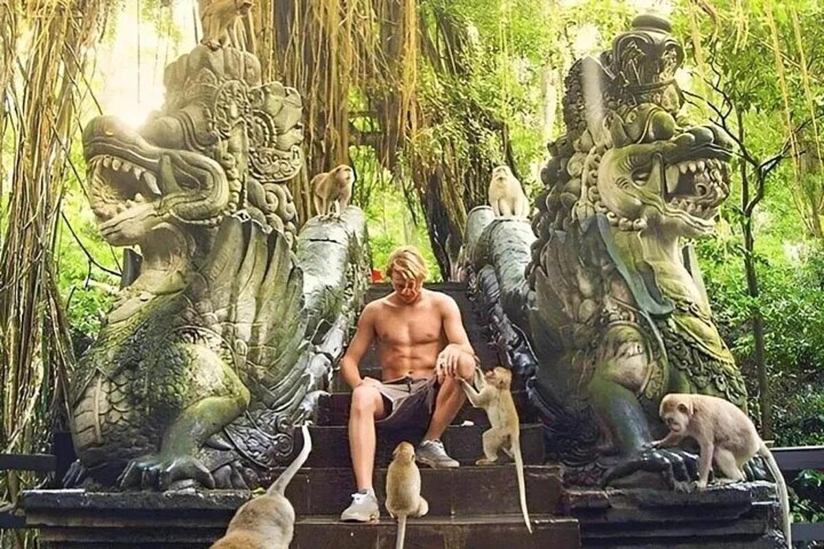 seorang lelaki duduk di atas patung dengan beberapa anjing