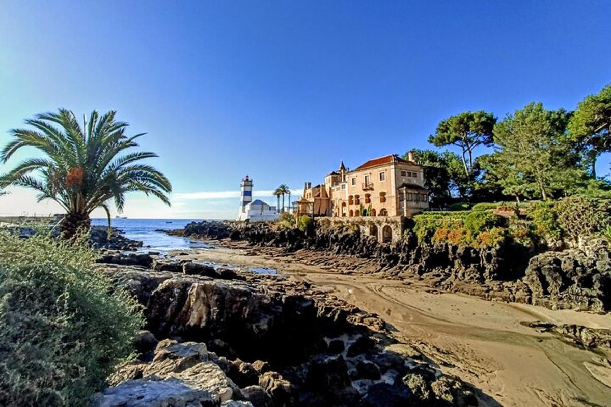 una casa sulla spiaggia con un faro sullo sfondo