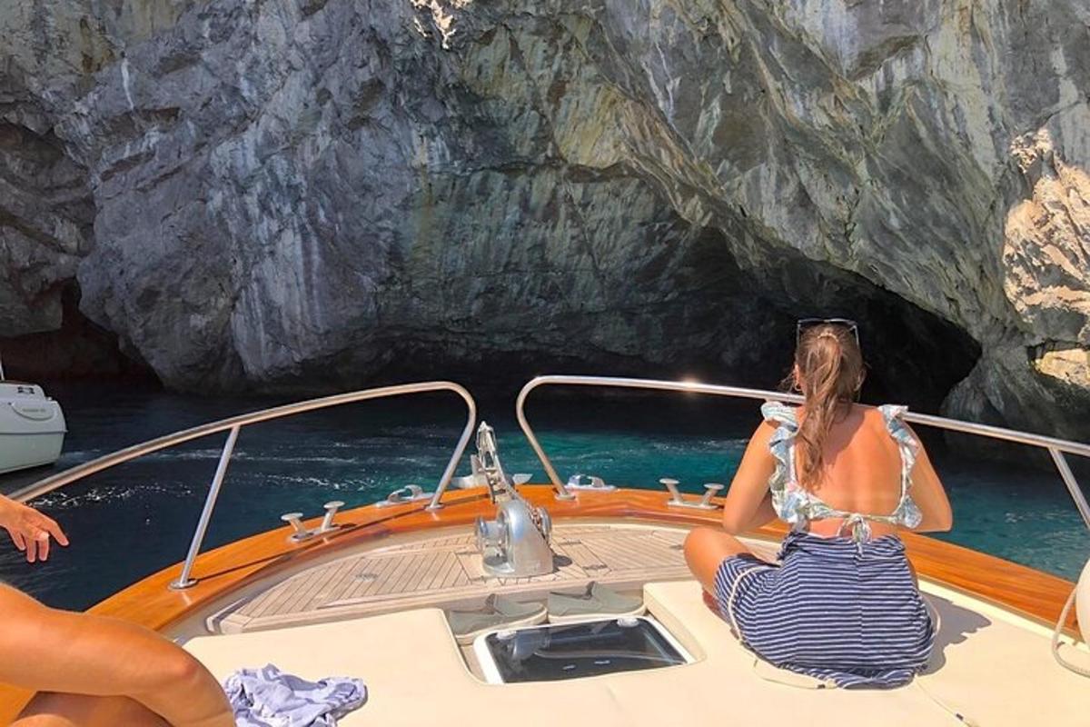 žena sedící na lodi před jeskyní