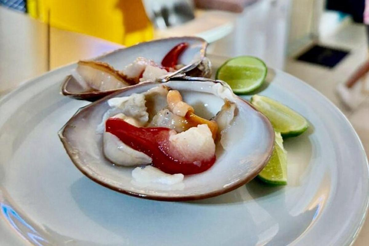 un plat blanc amb dues ostres amb pebrots i rodanxes de llima