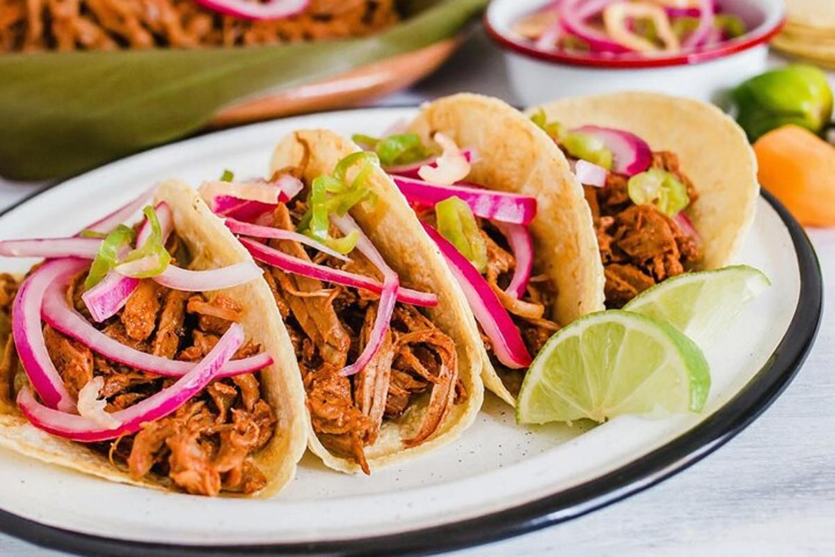 bílý talíř se třemi tacos z trhaného vepřového masa