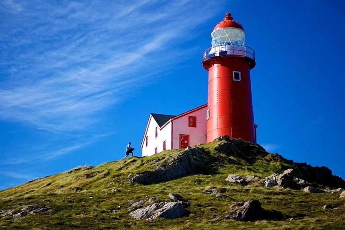a red lighthouse sitting on top of a hill