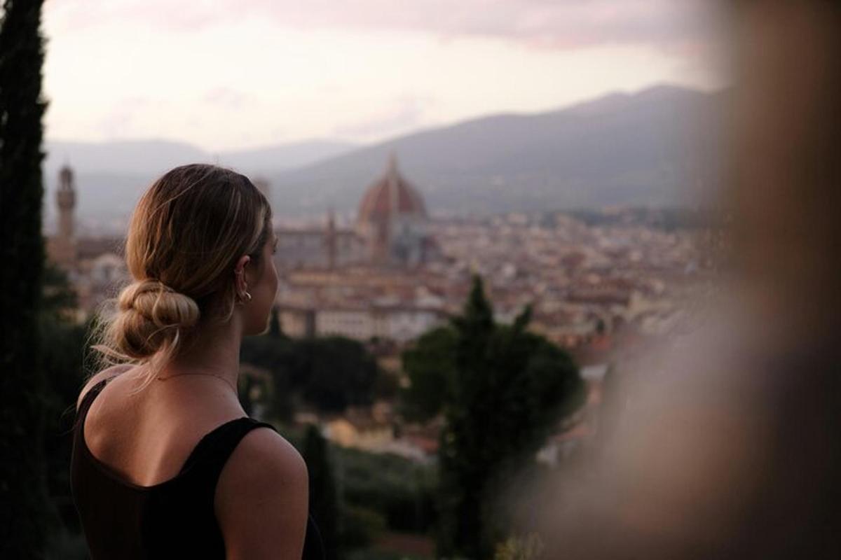 una donna che guarda una città da una collina