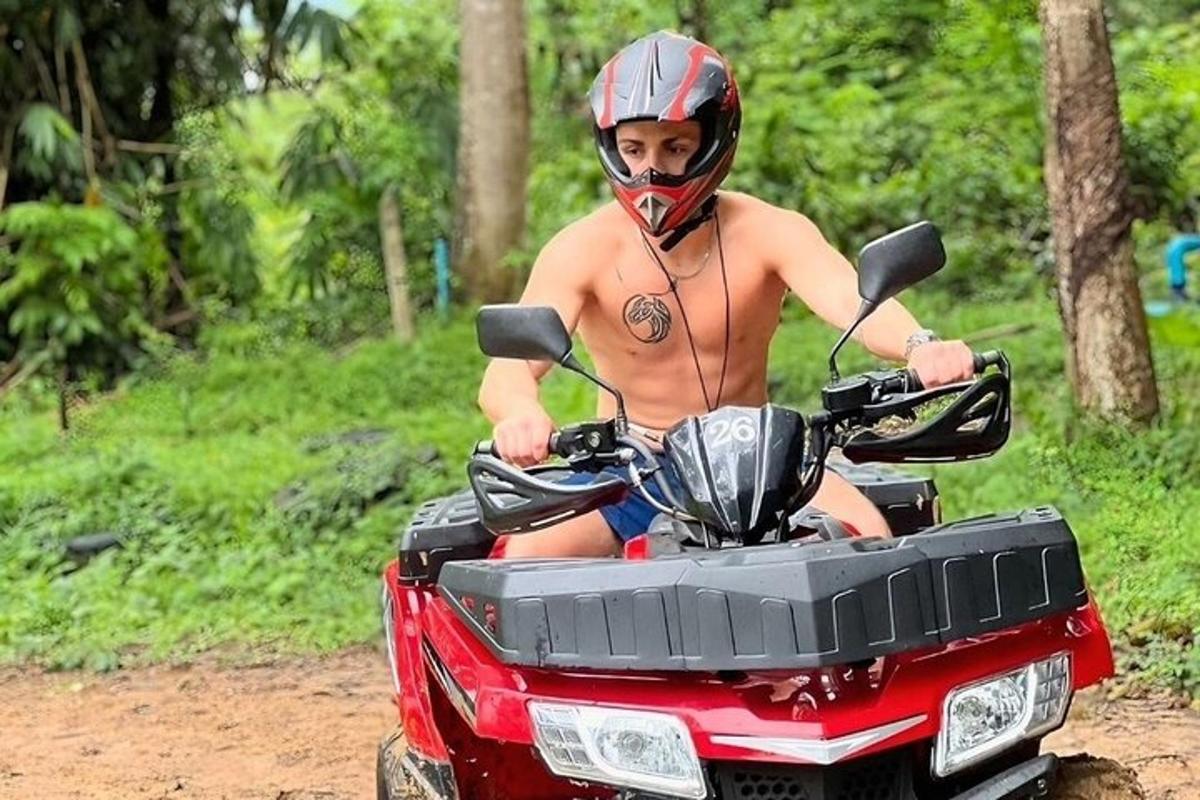 ヘルメットをかぶった上半身裸の男性がクワッドバイクに乗っている
