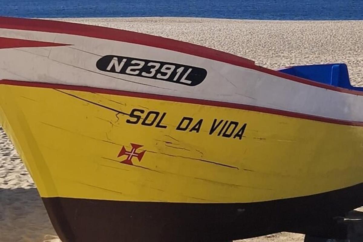 Un barco amarillo y rojo sentado en la playa