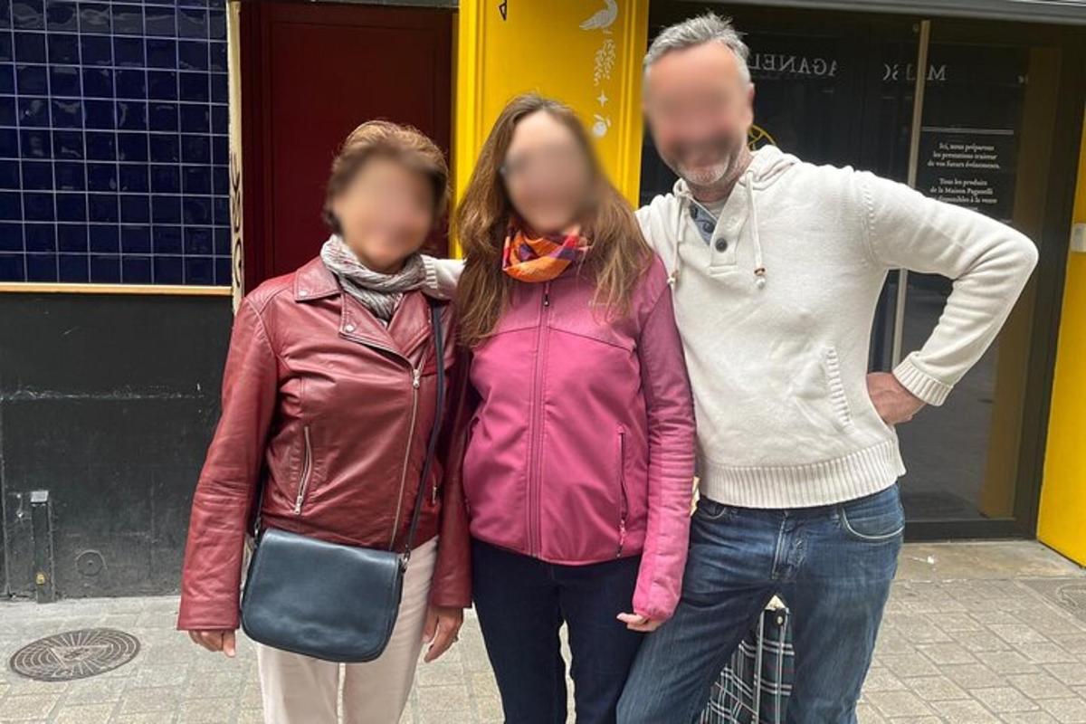 two women and a man walking down a street