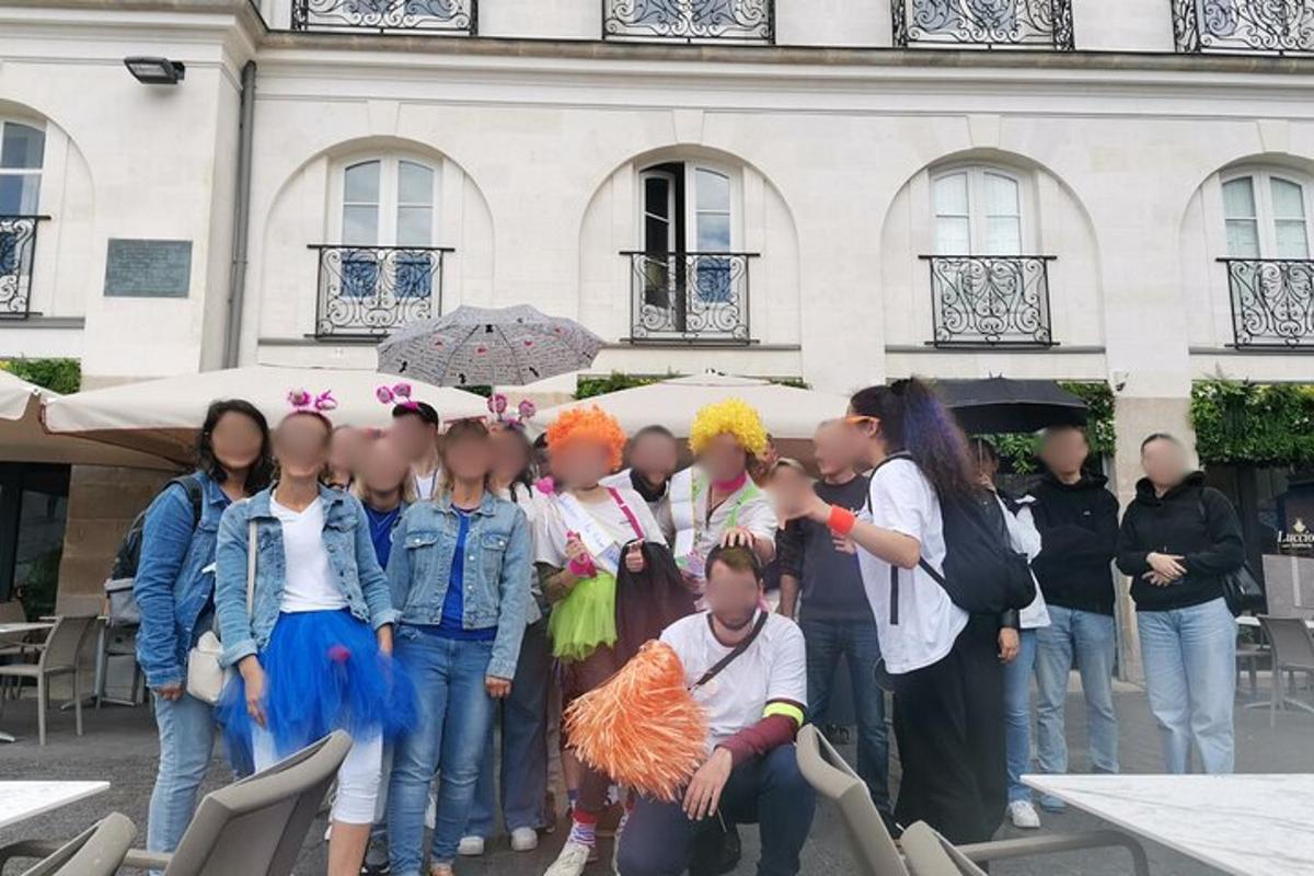 a group of children standing in front of a building with umbrellas