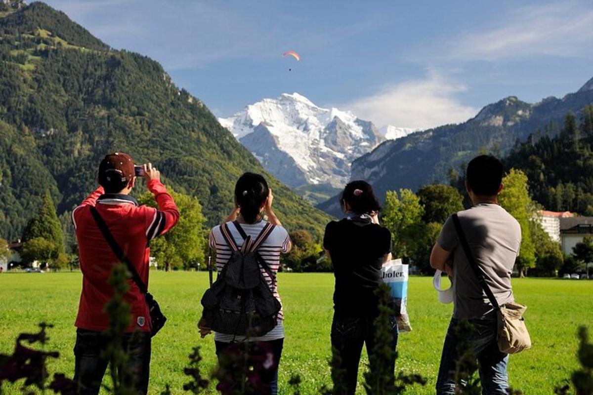 un grup de persones dempeus en un camp fent volar un estel