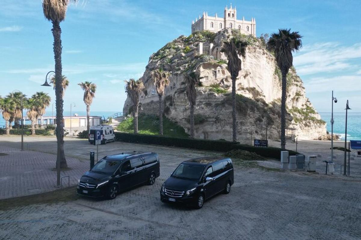 deux voitures garées sur un parking devant une montagne