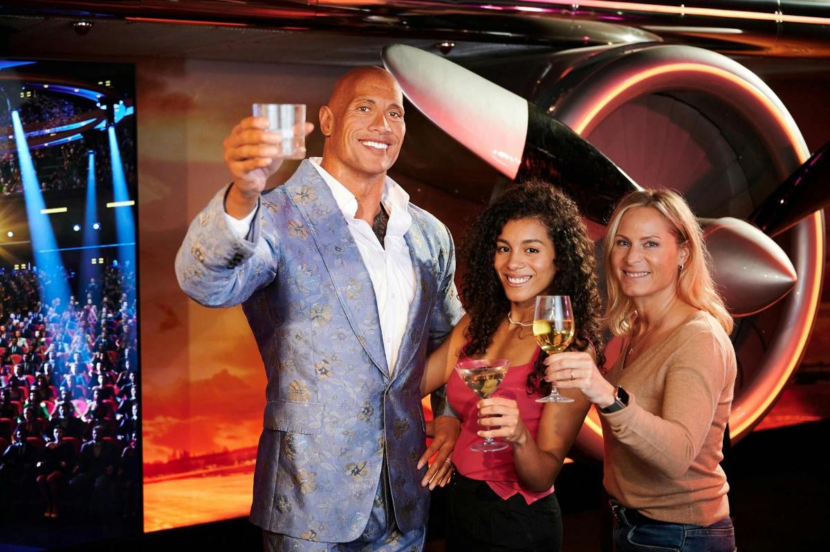 a man and two women holding glasses of wine