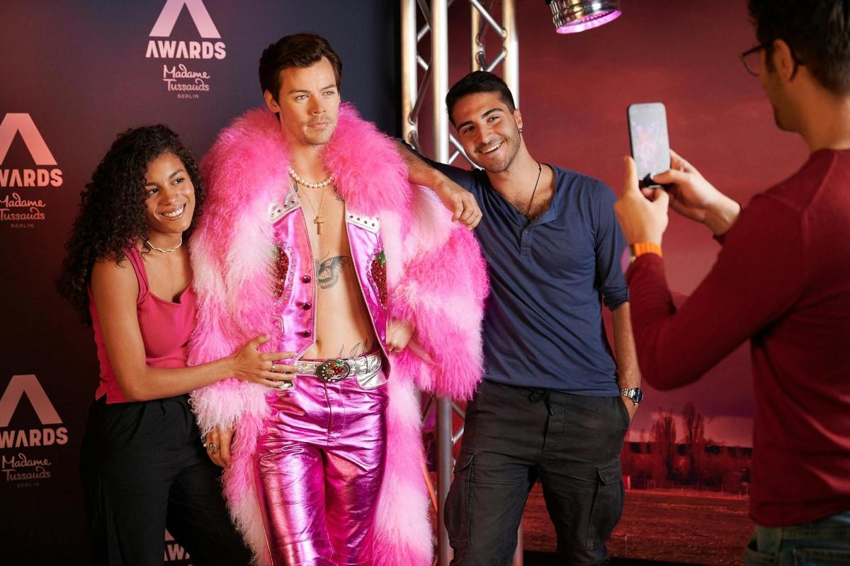 a woman in a pink fur suit standing next to two men