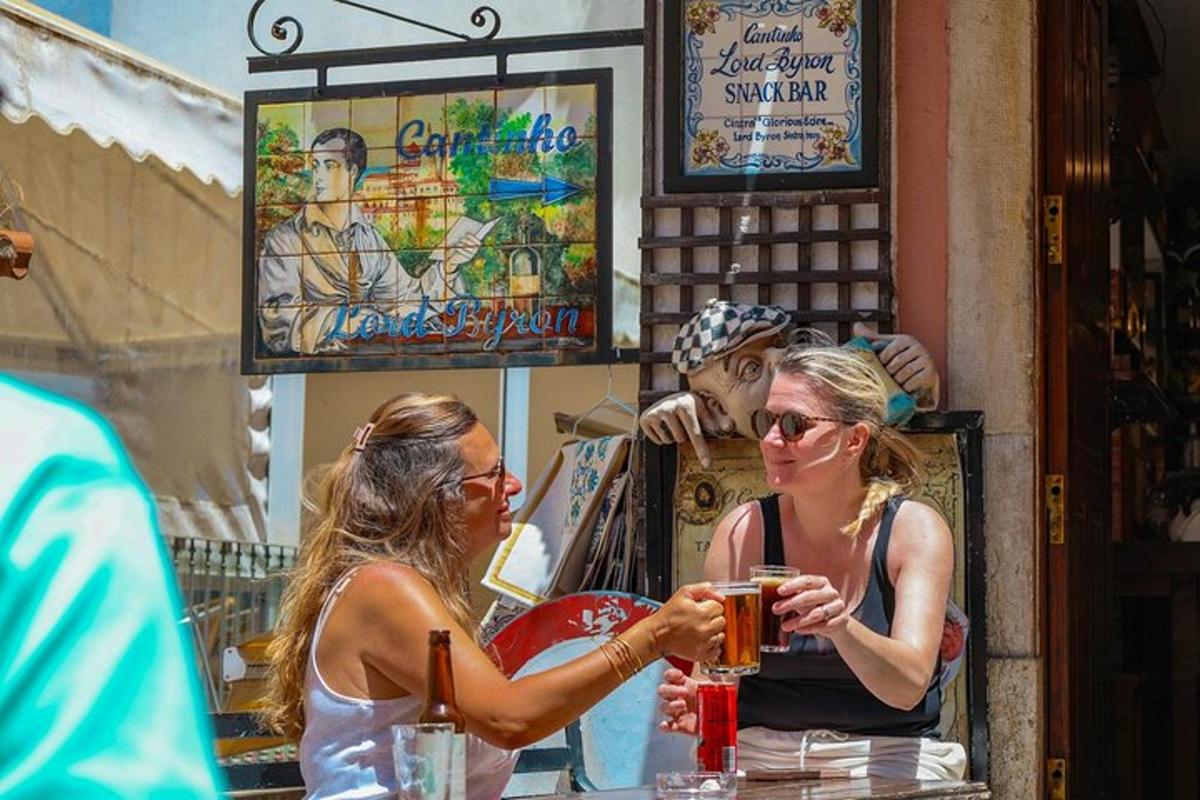 duas mulheres sentadas em um bar bebendo cerveja