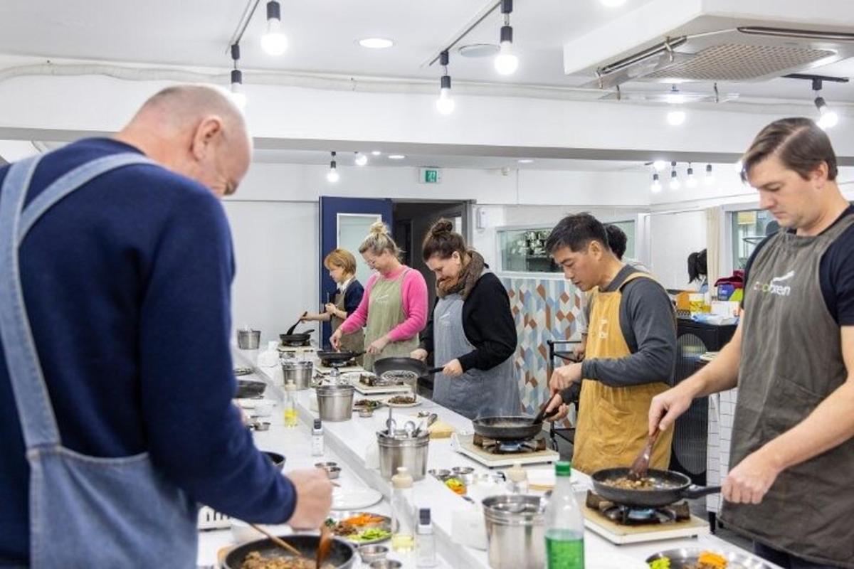 a group of people standing around a table preparing food