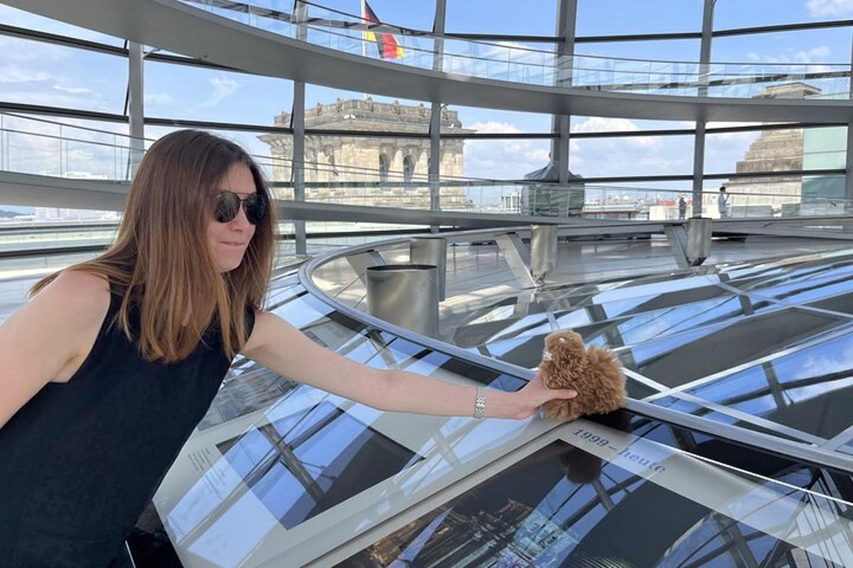žena ve slunečních brýlích držící plyšového medvídka
