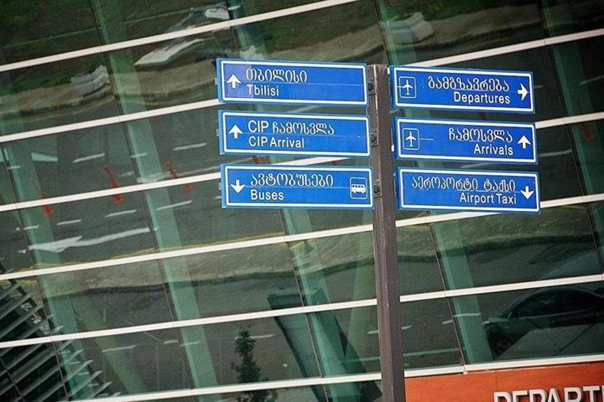 sloup s modrými dopravními značkami před budovou
