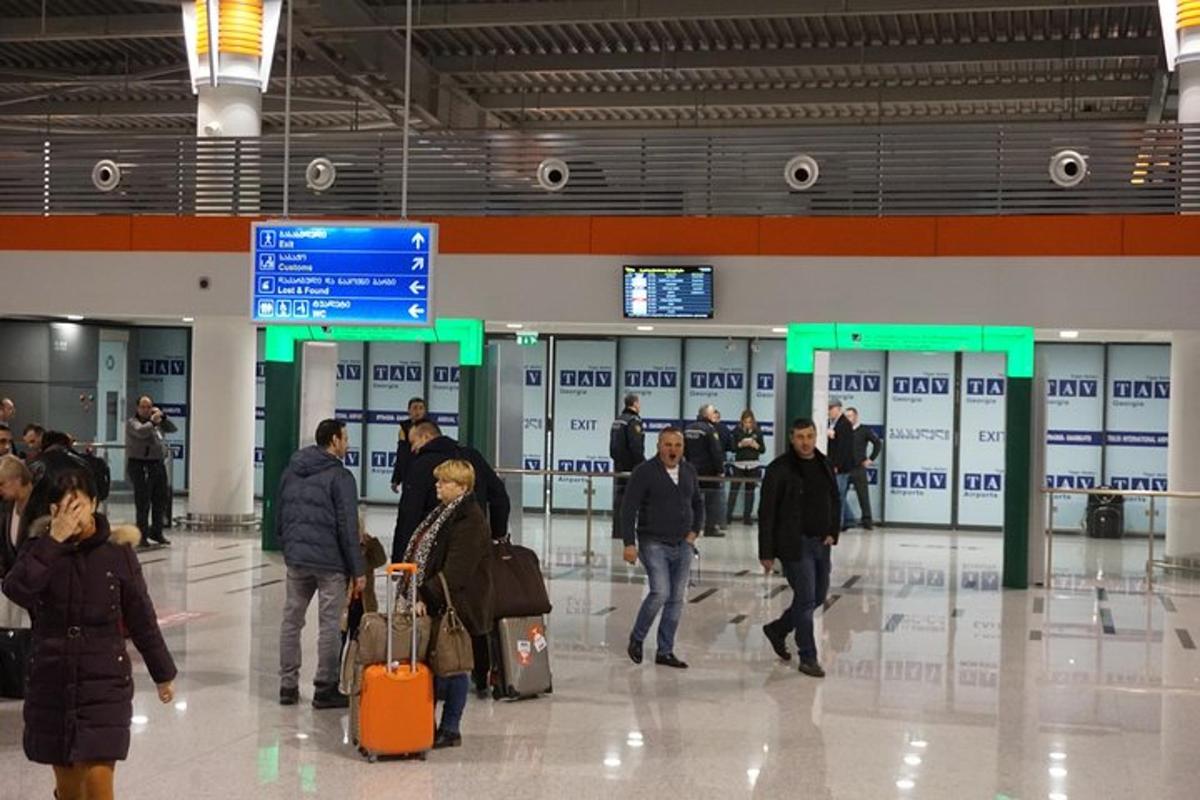 skupina lidí procházejících se po letišti