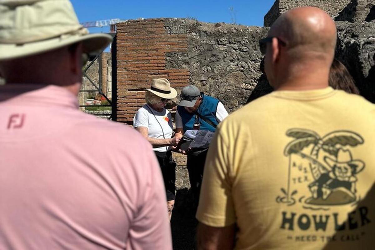 un gruppo di uomini in piedi accanto a un muro di mattoni