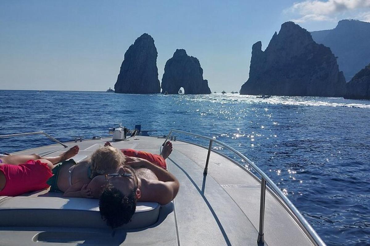 two people laying on the back of a boat in the water
