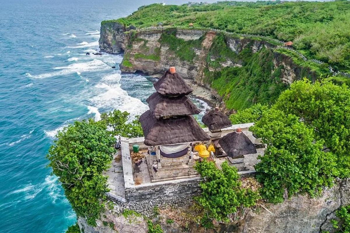 a small building on a cliff next to the ocean