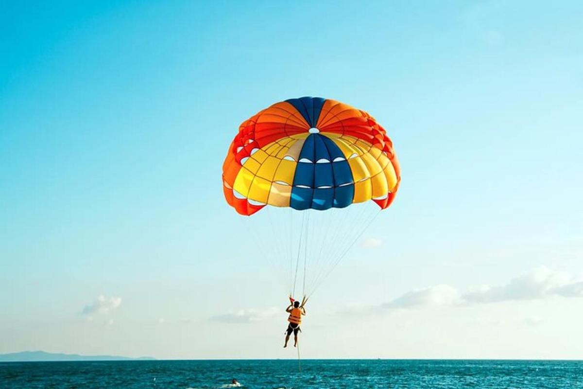 a person is riding a parachute over the ocean