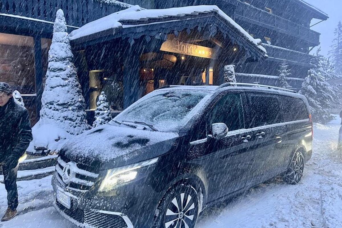 un uomo in piedi accanto a un'auto nella neve