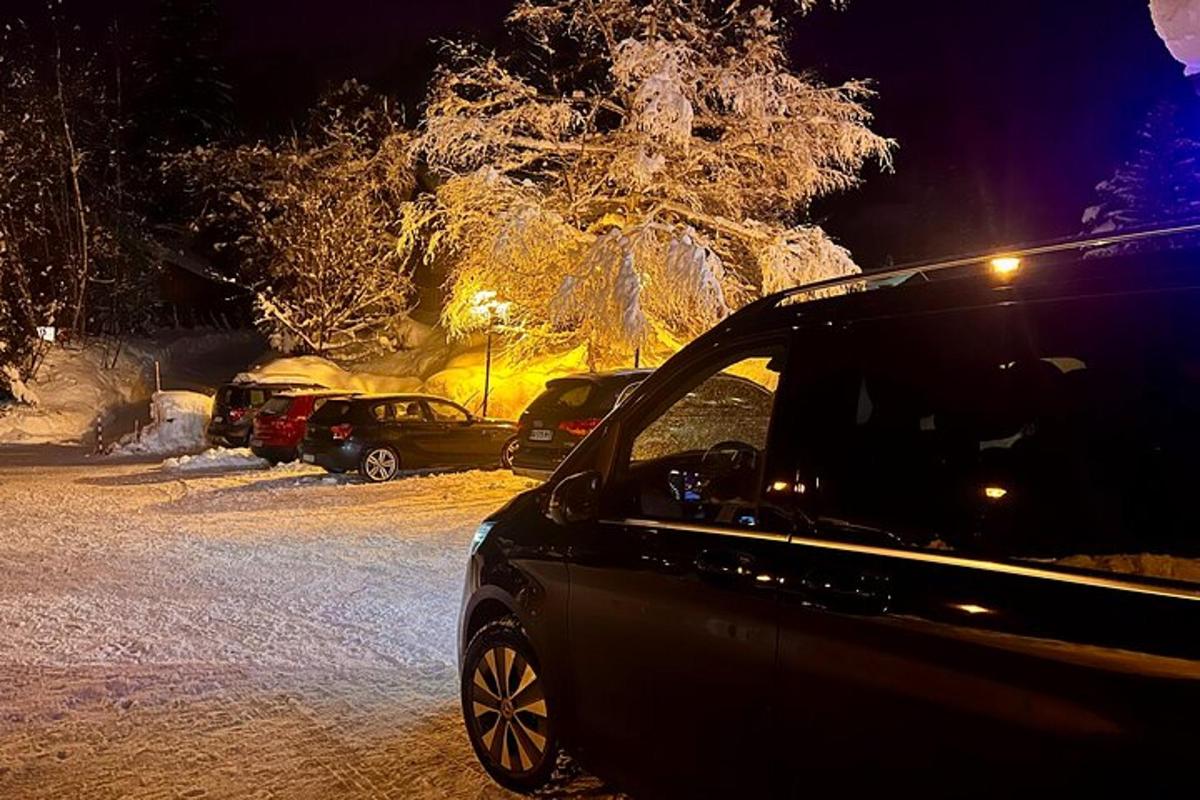 un'auto parcheggiata in un parcheggio coperto di neve di notte