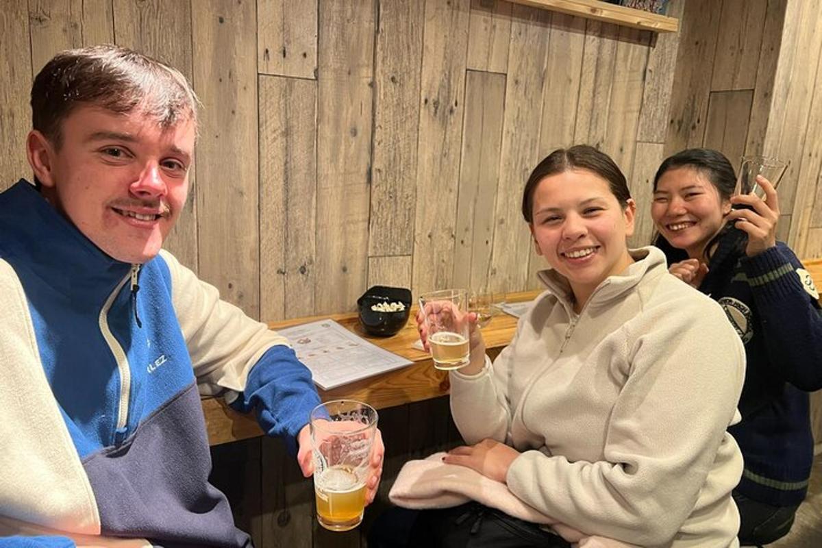 a group of people sitting at a table with glasses of beer