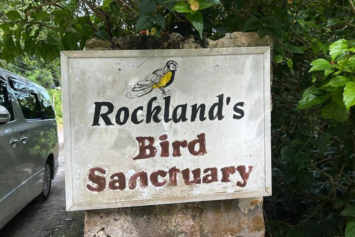 Un cartel que anuncia un santuario de aves adherido a un árbol.